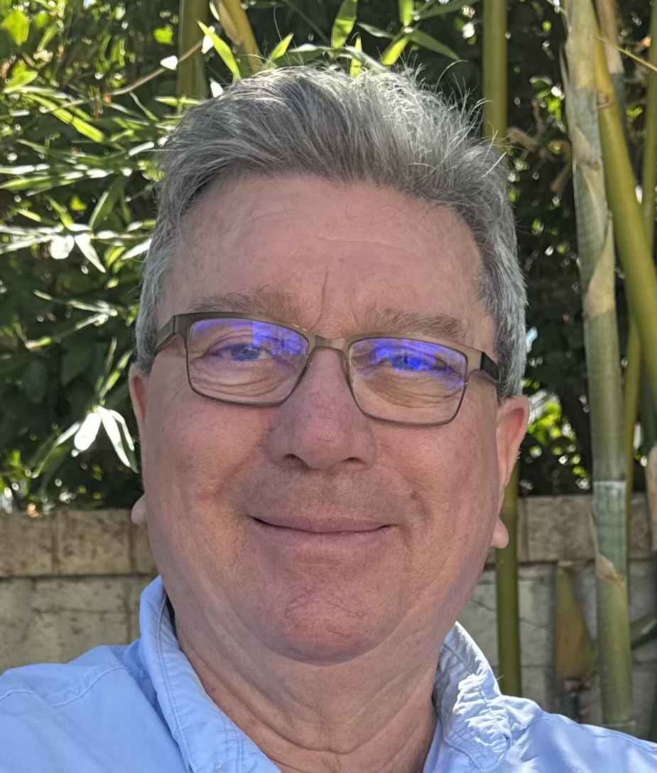 Les Jarrin, mobile notary public serving Ventura County and Greater Los Angeles, smiling outdoors wearing glasses and a light blue shirt